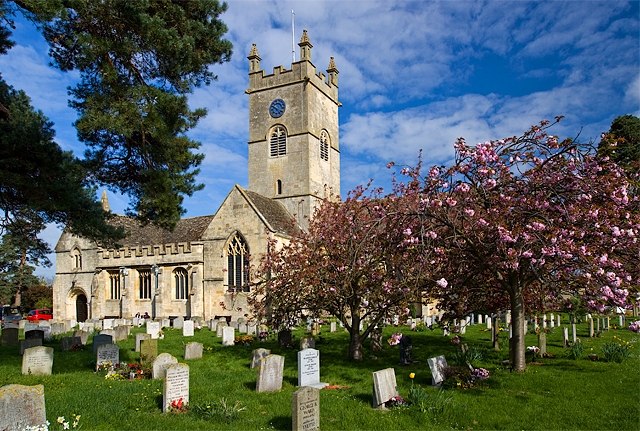 St Michael & All Angels Church in Bishop’s Cleeve, Cheltenham, surrounded by blossoming trees and a churchyard.